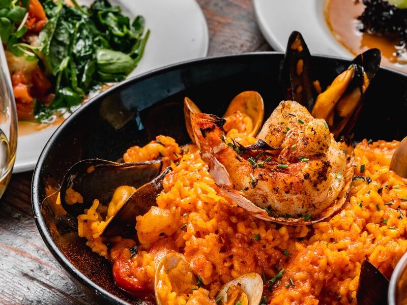 Pacific Paella with a grilled lobster tail, mussels, clams and saffron rice
